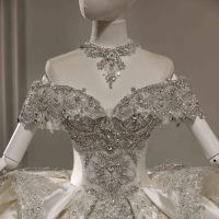 Robe de mariée moderne en satin ivoire, coupe princesse, épaules dénudées, manches courtes, ornée de perles, dentelle, broderies de cristaux et appliqués, taille naturelle