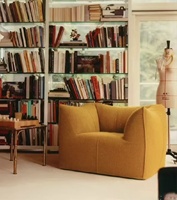 Canapé lounge avec mousse moulée monobloc, tissu bouclé couleur moutarde et accoudoirs hauts enveloppants pour un salon confortable