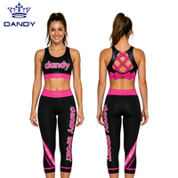 Ensemble d'entraînement de cheerleading personnalisé noir et rose avec soutien-gorge de sport à dos croisé et leggings capri pour femmes