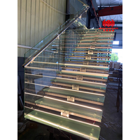 Escalier intérieur mono-tringle en acier avec marches en bois et garde-corps en verre