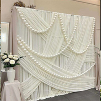 Mur de toile de fond élégant en satin blanc, rideau de fond luxueux à plis croisés avec chaîne de perles pour mariage en extérieur dans un jardin