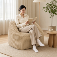 Neu eingetroffener Akzentstuhl: Luxuriöses, beige, abgerundetes Sofa mit breiter Sitzfläche in Kompressionsverpackung für moderne Wohnzimmer