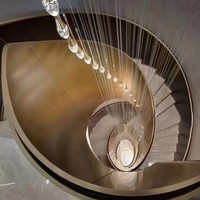 Rampe d'escalier moderne de luxe en acier courbé avec finition bronze antique et texture marbre en tons chauds pour villa intérieure