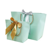 Venta al por mayor de boda de lujo bolsa de embalaje de regalo de logotipo personalizado a granel simple cinta de embalaje de ropa pequeña de compras de papel bolsa de regalo