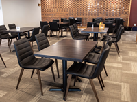 Ensemble table et chaises de restaurant moderne avec sièges rembourrés noirs et pieds en métal imitation bois pour café, bistrot, hôtel, salle à manger