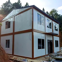 Maison conteneur démontable à ossature blanche, deux étages, toit à pignon, balcon, porte vitrée pour habitation familiale en banlieue