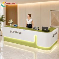 Comptoir de réception LED coloré de luxe sur mesure, comptoir d'accueil moderne pour bureau avec design de bordure incurvée dorée, mobilier pour hall d'hôtel, salon