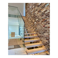 Innenliegende Stahltreppe mit Einzelwange, Holzstufen, Edelstahlhandlauf und Glasgeländer