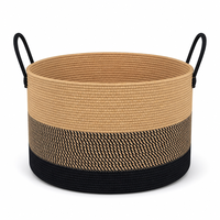 Panier de rangement en corde de coton avec design tressé noir et marron, poignées de transport pour l'organisation des couvertures dans le salon