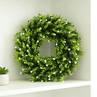 Minimalistische groene krans met kleine witte bloemen voor gebruik in de lente, zomer en het hele jaar door