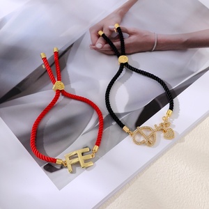 Set di 2 braccialetti Asu in corda nera e rossa con ciondoli dorati 'Dios' e 'FE', gioielli regolabili - Product Image 2