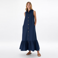 Gaun kemeja midi wanita custom grosir warna biru navy tanpa lengan, kerah runcing, kancing depan, saku samping, dan detail ruffle bertingkat.