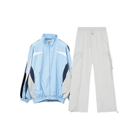 Ensemble survêtement streetwear pour homme : veste coupe-vent en nylon personnalisée avec logo brodé et patchwork, et pantalon baggy