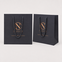 Sac shopping en papier noir mat de luxe avec poignée en corde, logo en feuille d'argent bronze, sac de transport en papier personnalisé