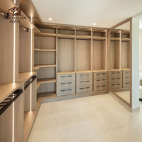 Grande dressing moderne ouverte avec finition en bois naturel et tiroirs à fermeture amortie