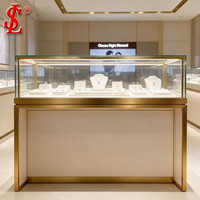 Vitrine de présentation de bijoux de luxe en verre doré, cadre en or brossé, éclairage LED, meuble de vente au détail, aménagement de boutique