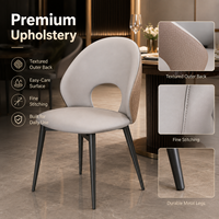 Chaise de salle à manger moderne à dossier ouvert, assise rembourrée grise courbée et matelassée avec pieds en métal pour hôtel et restaurant