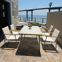 Ensemble table et chaises à cadre en aluminium avec sièges beiges et bords dorés pour terrasse extérieure