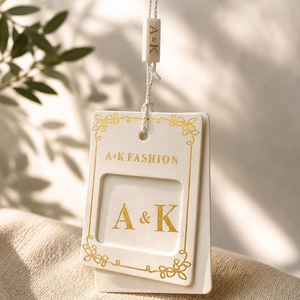 Étiquettes suspendues personnalisées de luxe en papier écologique avec estampage à chaud doré pour vêtements de marque - Product Image 1