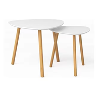 Ensemble de deux tables basses en forme de galet avec plateau blanc et trois pieds en bois, style scandinave moderne pour salon