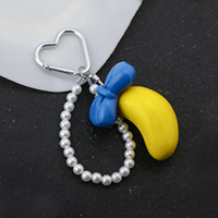 Vente en gros : Breloque de sac banane Kawaii tendance, porte-clés avec nœud et chaîne de perles et fermoir cœur, cadeau adorable pour filles