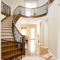 Escalier de luxe en bois courbé pour villas durable avec garde-corps en fer forgé et bandes de roulement en chêne massif fabriqué sur mesure à Foshan