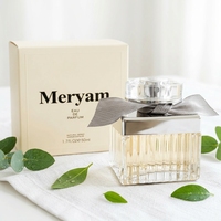 Parfum féminin en verre côtelé carré avec capuchon argenté, ruban taupe, boîte crème, senteur fleurie chaude, tenue longue durée, idéal pour les rendez-vous
