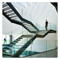 Escalier droit moderne et contemporain pour intérieur, à double poutre, structure acier-bois, garde-corps en verre, marches en pierre