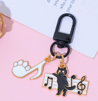 Porte-clés en alliage de zinc avec motif de petit chat noir musical de dessin animé et notes de piano, accessoire de sac mignon et original pour hommes et femmes