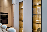 Meuble de cuisine moderne de luxe en bois clair sur mesure avec porte à panneau plat, îlot cascade en marbre et crédence pour villa