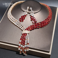 Ensemble collier et boucles d'oreilles en zircone vert émeraude, plaqué or, avec nœud croisé et franges asymétriques multi-rangs