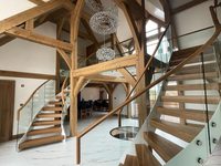 Escalier incurvé moderne en métal préfabriqué et bois, escalier intérieur en arc avec balustrade en verre sans cadre et couleur personnalisée