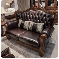 Canapé classique en cuir capitonné avec motif floral enroulé, ton bois riche, pièce maîtresse pour salons