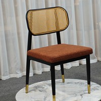 Chaise de salle à manger moderne en rotin nordique avec dossier, coussin bouclé, cadre noir et accents en laiton, pour la maison, le bar et l'appartement - Vente en gros directe usine