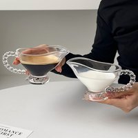 Carafe à crème en verre transparent avec poignée perlée et base sur pied, verseuse à lait pour le service de café et de thé sur table