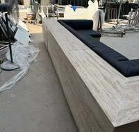 Canapé d'angle en travertin sur mesure, moderne, écologique, avec structure en pierre beige et coussins en cuir noir, idéal pour appartement de luxe