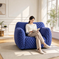 Fauteuil d'appoint moderne en tissu matelassé bleu avec accoudoirs arrondis en peluche