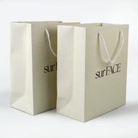 Sac de shopping en carton blanc épais de luxe avec logo personnalisé pour l'emballage de vêtements, de cosmétiques et de cadeaux