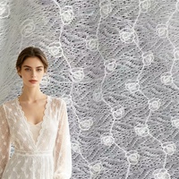 Tissu en dentelle crochetée blanche avec motif floral médaillon et cordon, matière en dentelle tricotée pour robes de mariée et rideaux