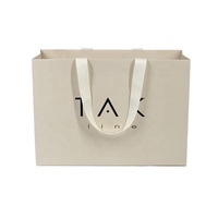 Sac en papier de haute qualité pour le shopping, impression personnalisée du logo avec logo noir, insert en feuille d'aluminium, poignée en ruban pour emballage cadeau