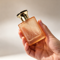 Flacon de parfum en verre ambré pêche 50ml 1.7oz texture craquelée avec col doré et capuchon noir et or, vente en gros et approvisionnement en vrac