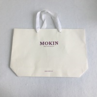 Sac cadeau en papier kraft noir recyclable écologique de luxe avec logo personnalisé, poignée en ruban pour l'emballage de cosmétiques