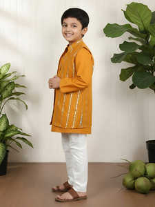 Niño sonriente con kurta naranja tradicional y pantalones blancos, posando en interiores, ropa étnica festiva, retrato de niño feliz - Product Image 3