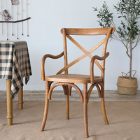 Chaise de restaurant à dossier croisé avec structure en bois et accoudoirs, siège rembourré en rotin