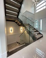 Escalier flottant moderne avec marches en bois droit, garde-corps en verre et éclairage LED