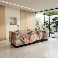 Îlot de cuisine moderne de luxe en marbre rose naturel du Portugal avec évier intégré, bord cascade et table de préparation avec armoire