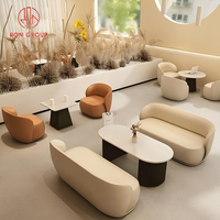 Ensemble de mobilier de café avec canapé incurvé beige brun en cuir et table ovale en marbre pour restaurant