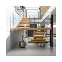 Escalier flottant sur mesure avec marches en chêne, main courante en laiton, balustrade en corde, style nautique