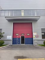 Portes sectionnelles en acier industrielles modernes avec fenêtres, design coupe-vent, surface finie pour usines et entrepôts