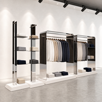 Vitrine de présentation de vêtements en acier inoxydable miroir avec dessus arrondi, tringle de suspension et socle blanc sur mesure